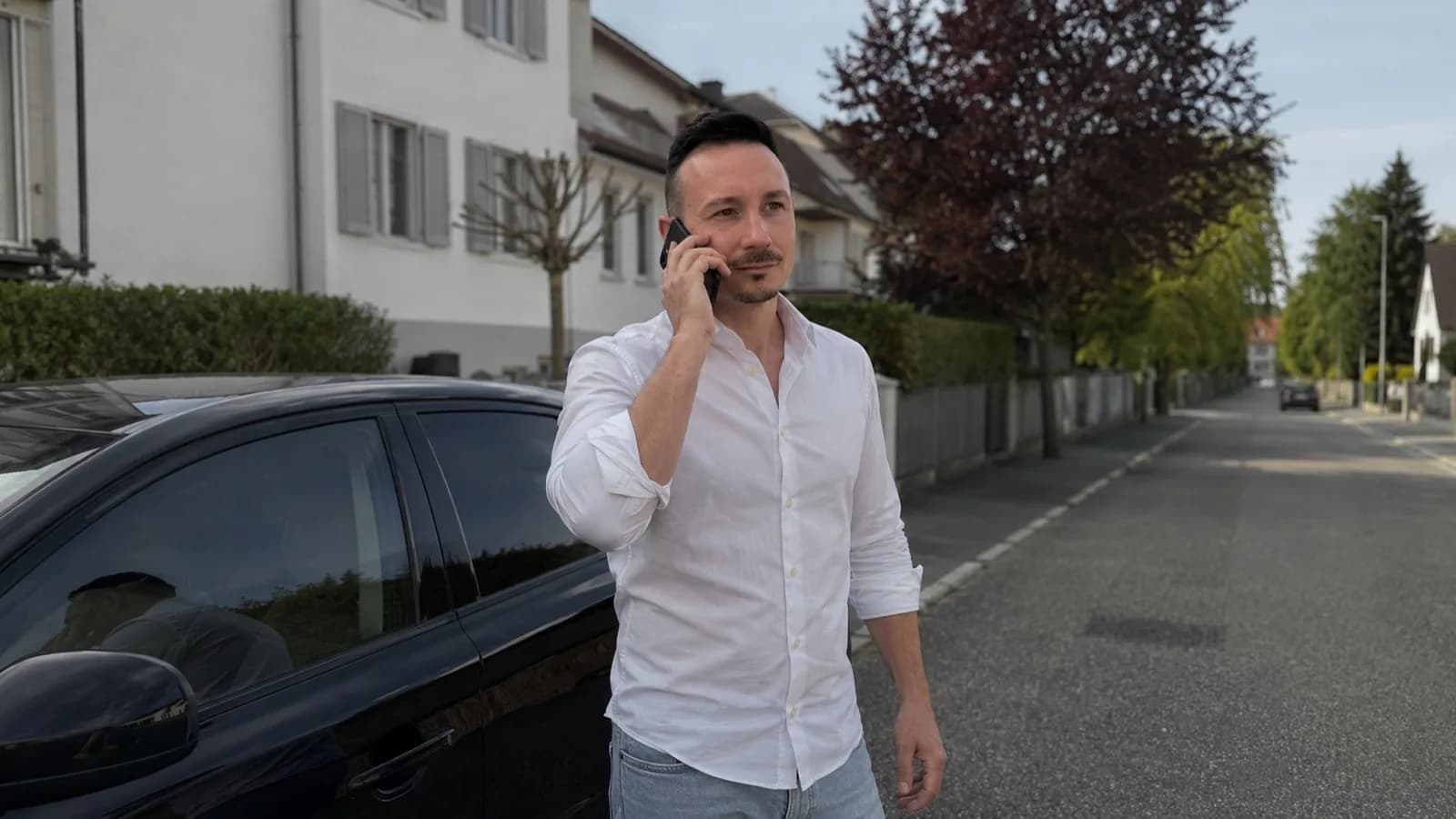 Manuel Dandler telefoniert zwischen zwei Terminen neben seinem Auto